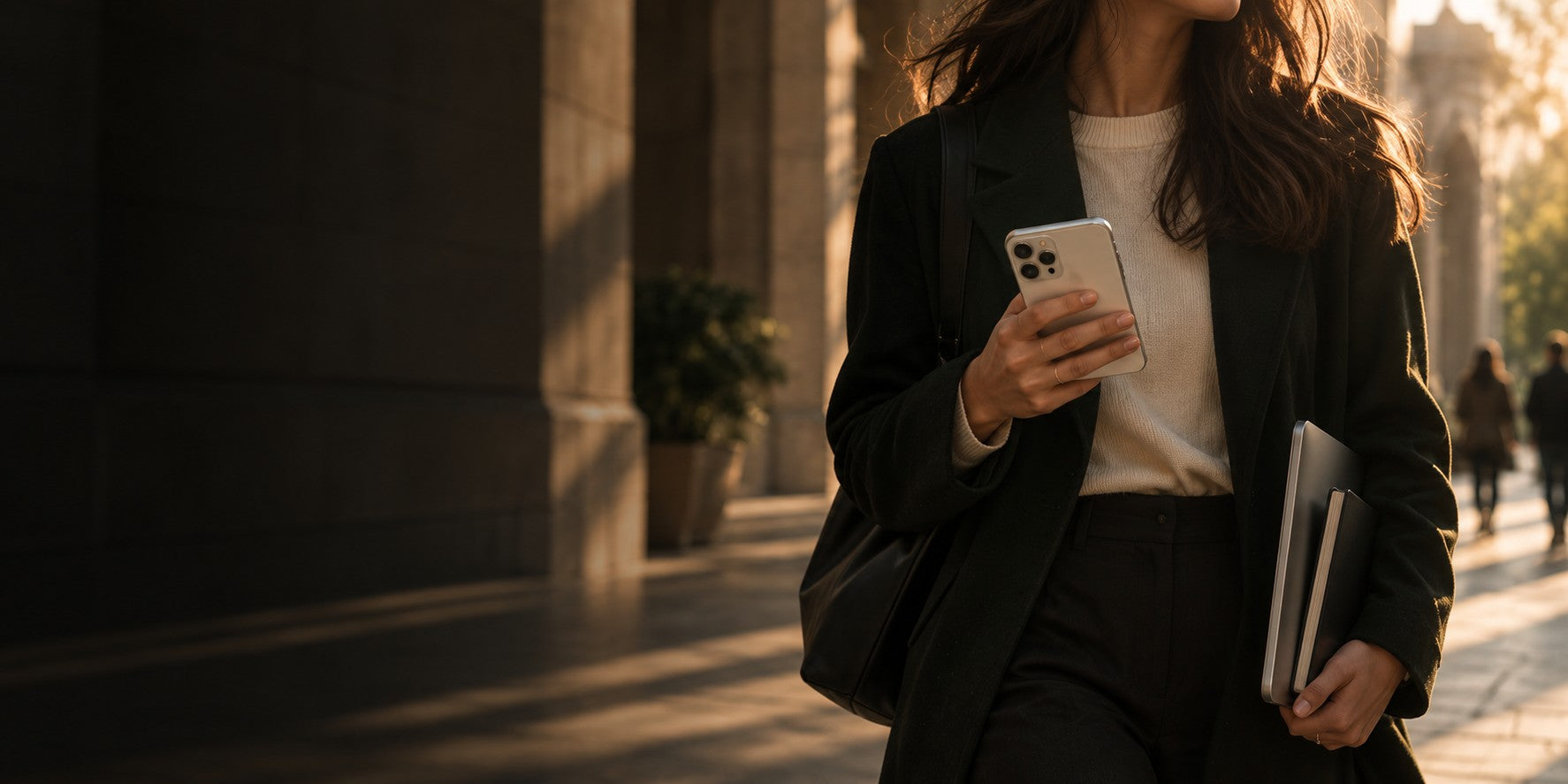 An iPhone 16 in black, photographed by Revivo against a warm neutral ground.