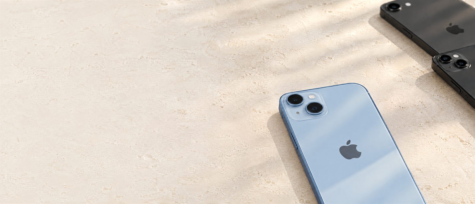 Editorial Revivo iPhone collection image with blue and black iPhones on pale travertine.